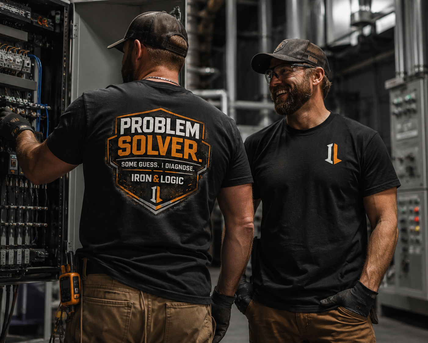 Two men in a workshop setting, one wearing a 'Problem Solver' shirt.